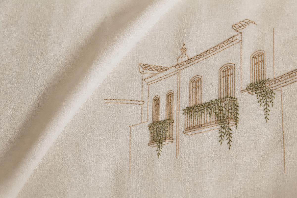 Tecido bordado com contorno de casas coloniais